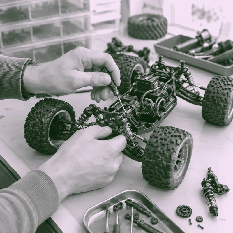 Técnico ajustando el chasis de un auto RC con herramientas